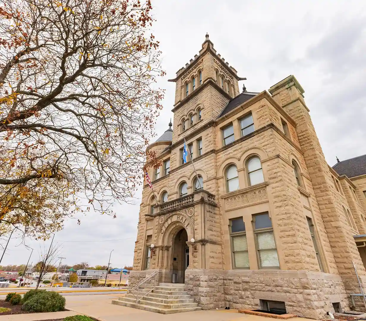 Historic sandstone city hall framed by autumn trees, the kind of landmark charter bus groups visit from Springfield, Virginia