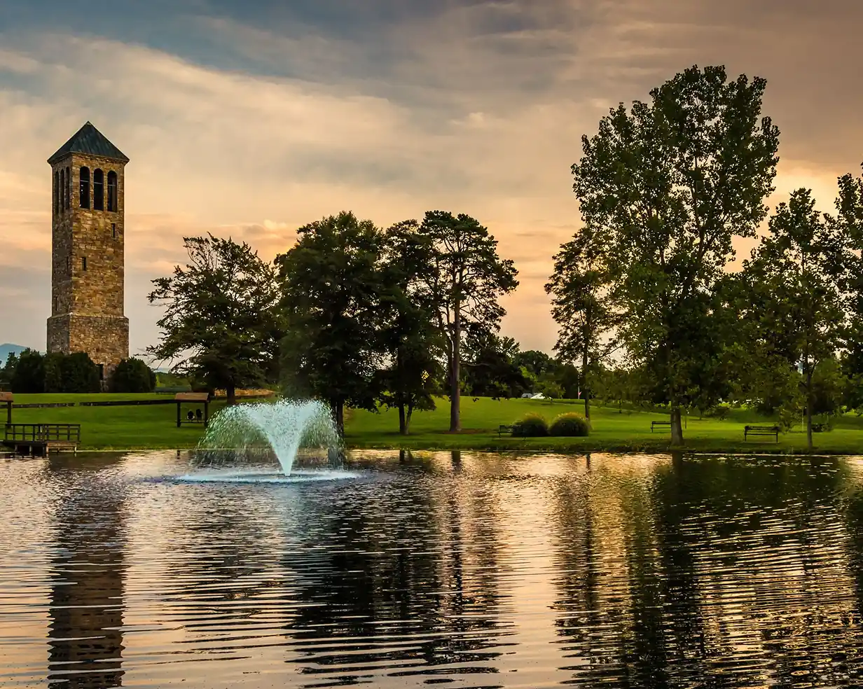 Stone bell tower and fountain pond at sunset in Springfield, Virginia, where charter bus groups stage for DC day trips