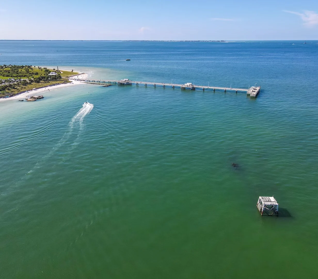 Aerial view of the St. Pete Pier and a boat on the turquoise bay in St. Petersburg, Florida, a stop on charter bus group itineraries