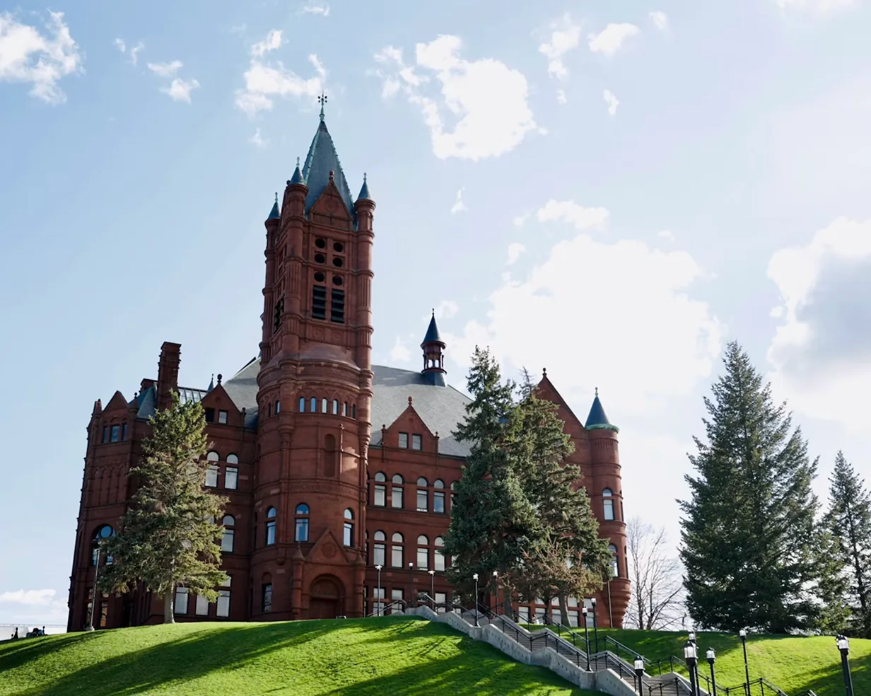Crouse College's Romanesque tower on a green hillside at Syracuse University in Syracuse, New York, on the campus-visit route for charter bus groups