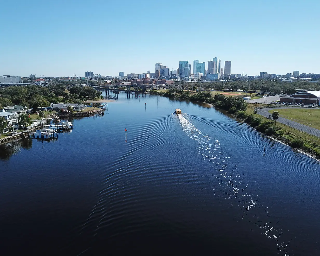 Aerial view of a boat on the waterway below the downtown Tampa, Florida skyline, a common pickup area for charter bus groups