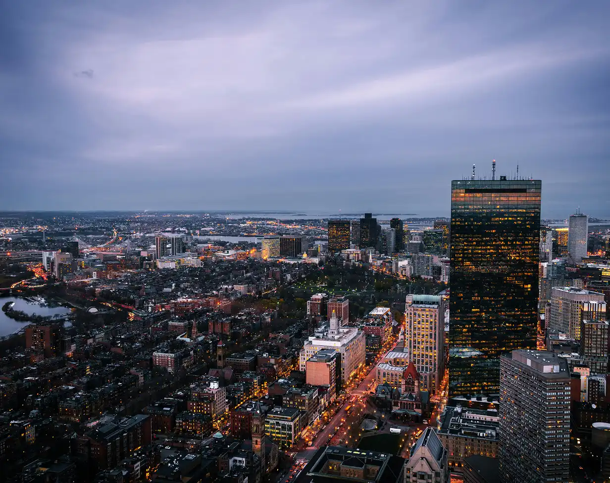 Charter bus rental Boston skyline at night.