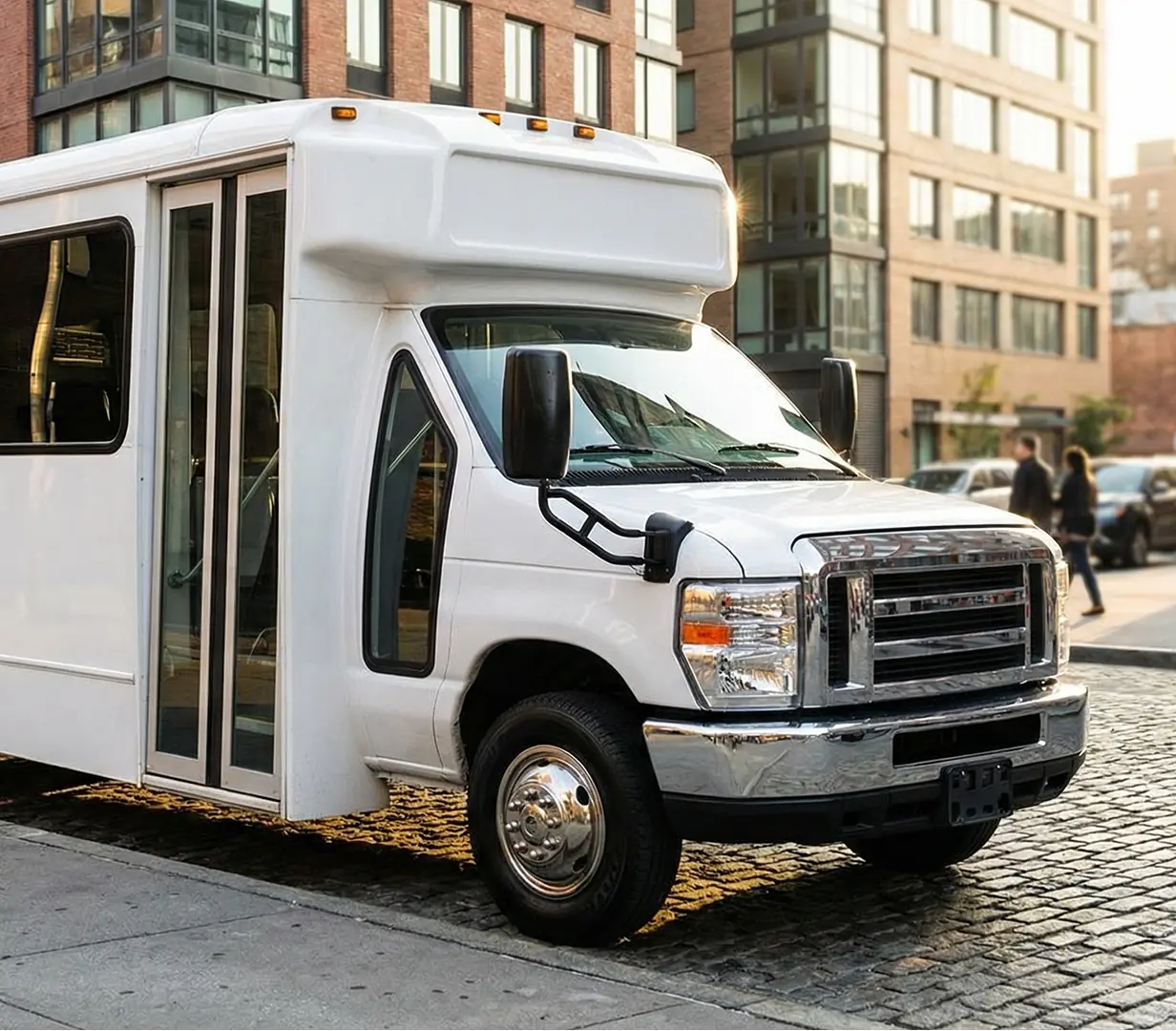 Shuttle bus on cobblestone street.