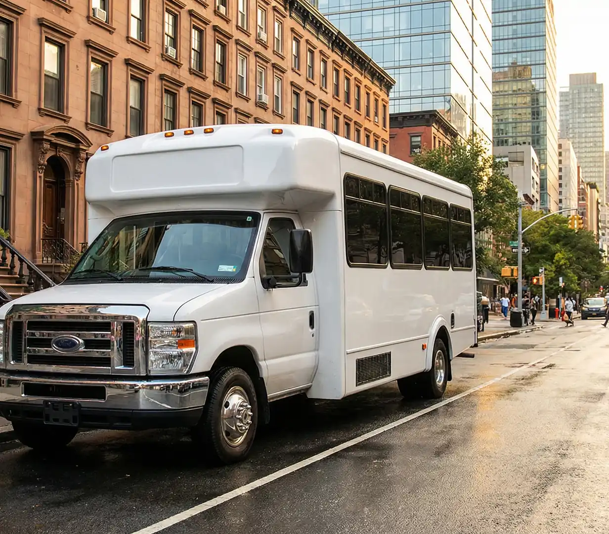 White shuttle bus on brownstone street.