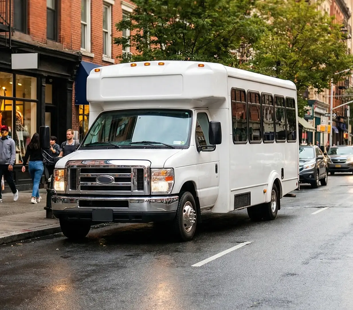 White shuttle bus on city street.