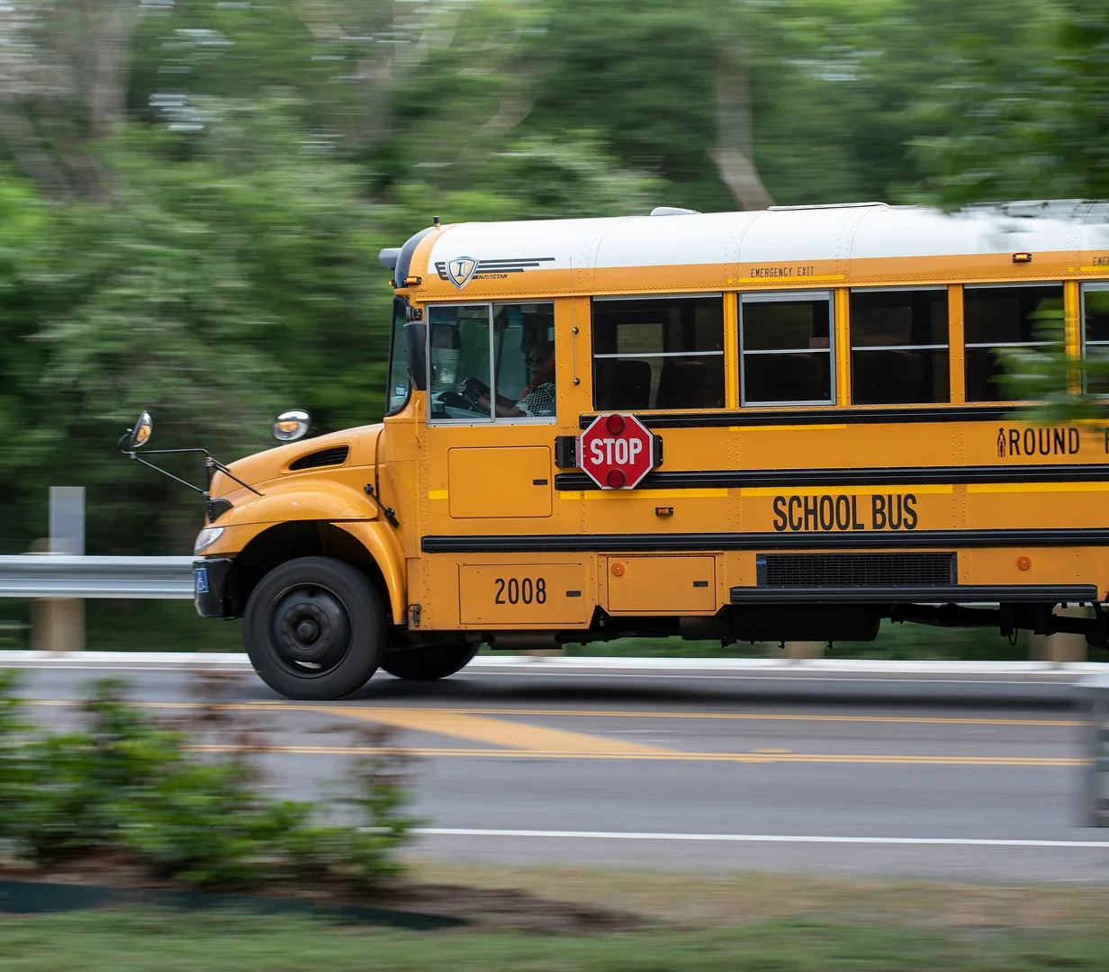 Yellow school bus on road with motion blur.